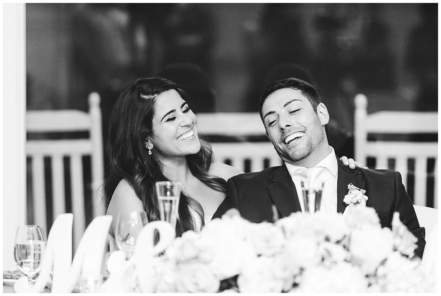 Bride and groom laughing in black and white