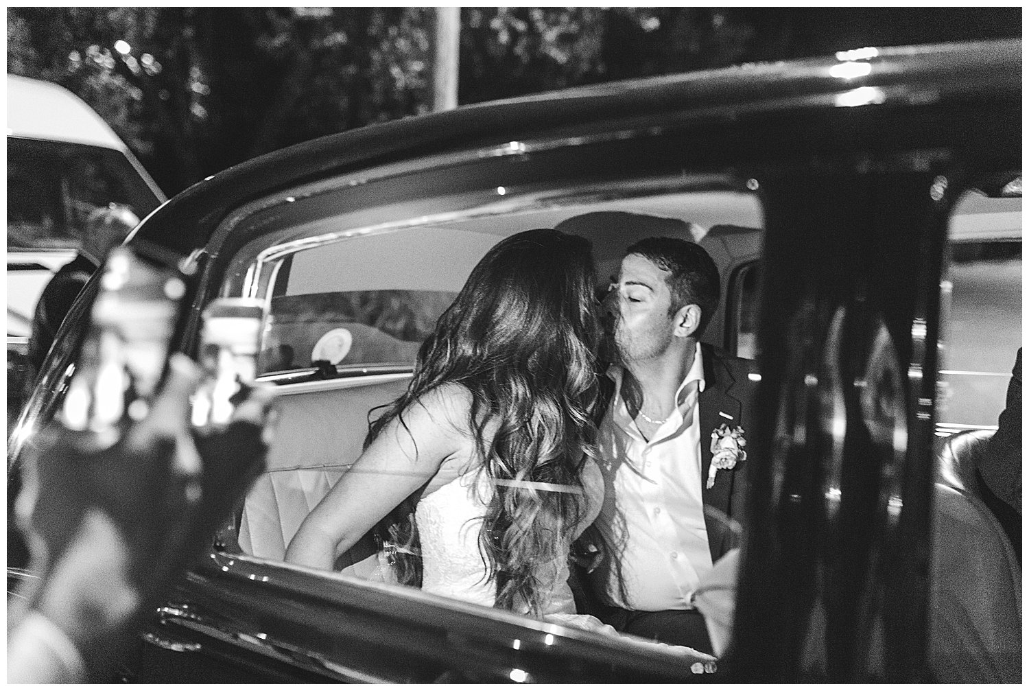 Bride and groom exit in classic car